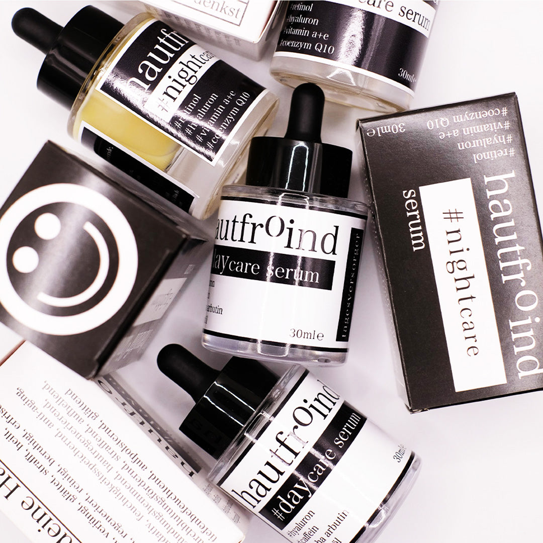 Hautfroind Daycare & Nightcare Seren – feuchtigkeitsspendende Hautpflege und Gesichtspflege für Tag & Nacht. Mit Hyaluronsäure, Retinol & Coenzym Q10 für Hydratation, Schutz & Regeneration. Fördert die Kollagenproduktion & sorgt für strahlende, glatte & gesunde Haut rund um die Uhr. Hautfroind Daycare Serum und HAutfroind NIghtcare Serum als Flaschen und Verpackungen künstlerisch und wild angeordnet.