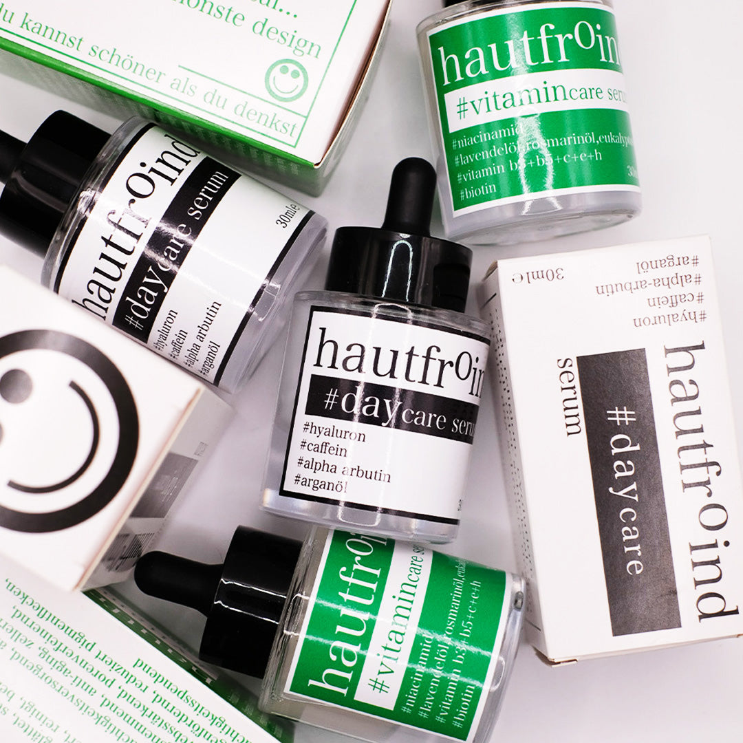 Hautfroind Daycare & Vitamincare Seren – feuchtigkeitsspendende Hautpflege und Gesichtspflege mit Hyaluronsäure, Vitamin C & Niacinamid. Spendet Feuchtigkeit, fördert die Kollagenproduktion & schützt vor freien Radikalen. Für eine strahlende, gesunde & perfekt gepflegte Haut. Hautfroind Daycare Serum und Hautfroind Vitamincare Serum, Flaschen und Verpackungen, sind wild angeordnet, künstlerisch.