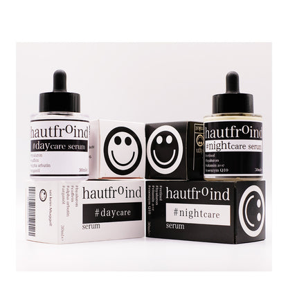 Hautfroind Daycare & Nightcare Seren – feuchtigkeitsspendende Hautpflege und Gesichtspflege für Tag & Nacht. Mit Hyaluronsäure, Retinol & Coenzym Q10 für Hydratation, Schutz & Regeneration. Fördert die Kollagenproduktion & sorgt für strahlende, glatte & gesunde Haut rund um die Uhr. Die Flaschen Hautfroind Daycare Serum steht neben der Flasche Hautfroind NIghtcare Serum. Frontal fotografiert vor hellem Hintergrund. Die Verpackung stehen daneben. Die Oberseite der Verpackungen zeigt Smileys.