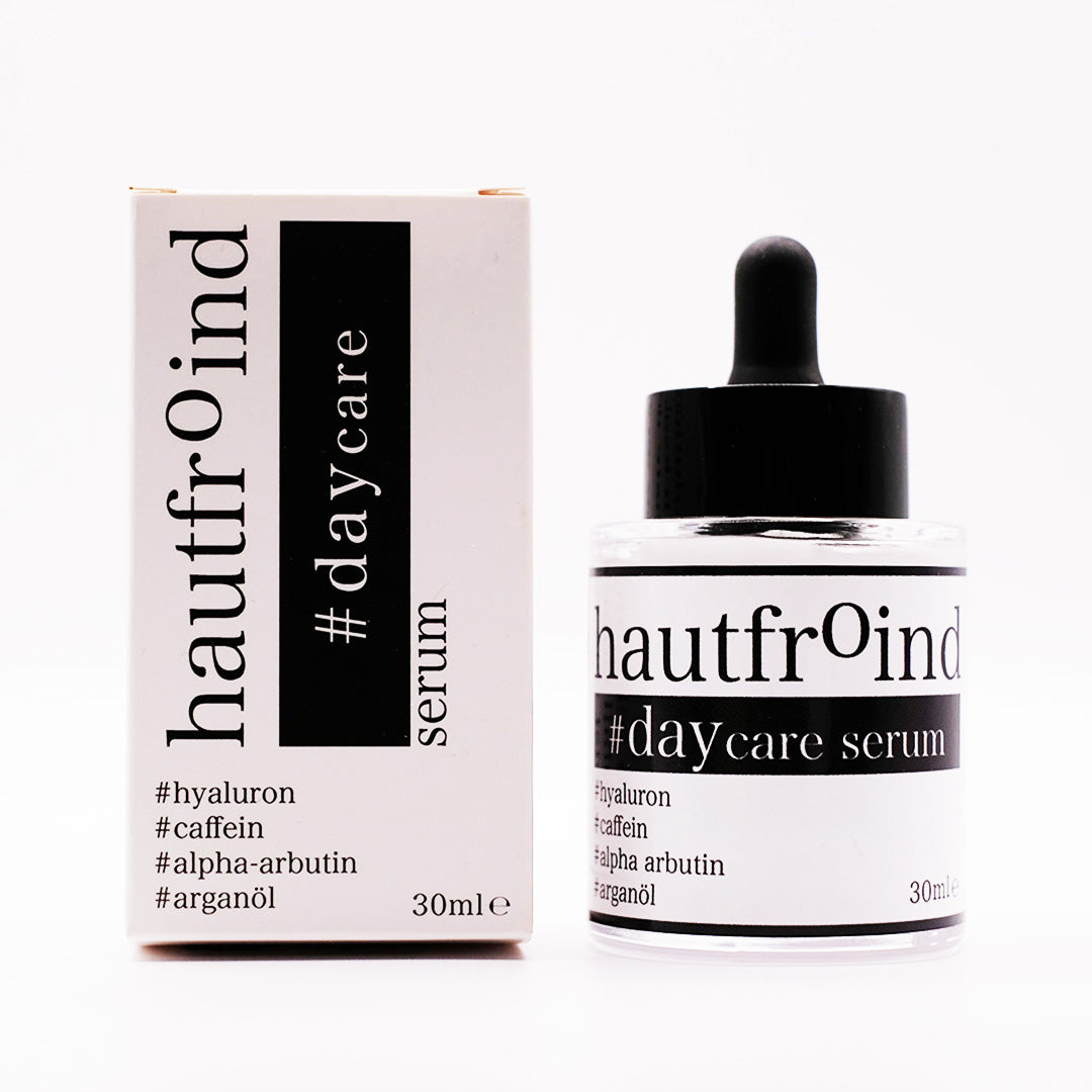 Hautfroind Daycare Serum – feuchtigkeitsspendende Hautpflege für das Gesicht mit Hyaluronsäure, Arganöl & Rosa Damascena Blütenwasser. Stärkt die Hautbarriere, verfeinert den Teint & sorgt für langanhaltende Feuchtigkeit. Leichte, schnell einziehende Gesichtspflege für strahlende Haut. Auf dem Foto ist die Flasche Daycare Serum und die Verpackung des Serum zu sehen. In Großaufnahme und Frontal fotografiert. 