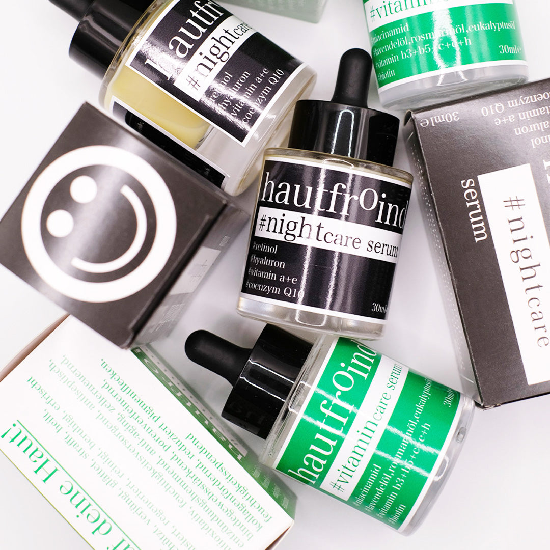 Hautfroind Vitamincare & Nightcare Seren – intensive Hautpflege und Gesichtspflege mit Vitamin C, Retinol & Hyaluronsäure. Versorgt die Haut Tag & Nacht mit Feuchtigkeit, stärkt die Kollagenproduktion & fördert die Regeneration. Für einen strahlenden, ebenmäßigen & jugendlichen Teint. Die Flaschen Hautfroind Nightcare Serum und hautfroind Vitmaincare Serum sind wild und künstlerisch mit den Verpackungen vor einem hellen Hintergrund angeordnet. 
