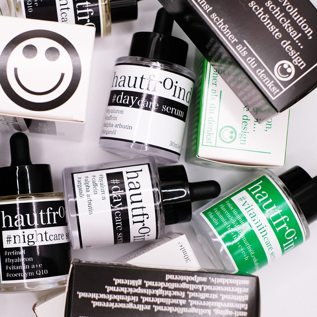Alt-Text: Hautfroind Daycare, Vitamincare & Nightcare Seren – Rundum-Hautpflege und Gesichtspflege mit Hyaluronsäure, Vitamin C & Retinol. Spendet Feuchtigkeit, schützt vor freien Radikalen & fördert die Regeneration. Für eine strahlende, hydratisierte & glatte Haut – Tag & Nacht. Hautfroind Vitamincare Serum, Hautfroind Daycare Serum und hautfroind NIghtcare Serum und die Verpackungen sind wild und künstlerisch angeordnet, vor einem hellen Hintergrund. 