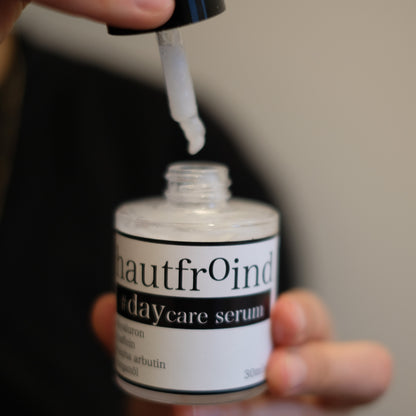 Hautfroind Daycare Serum – feuchtigkeitsspendende Hautpflege für das Gesicht mit Hyaluronsäure, Arganöl & Rosa Damascena Blütenwasser. Stärkt die Hautbarriere, verfeinert den Teint & sorgt für langanhaltende Feuchtigkeit. Leichte, schnell einziehende Gesichtspflege für strahlende Haut. Auf dem Foto ist zu sehen wie die Pipette einen tropfen des Serums in die Flasche Daycare tropfen lässt. 